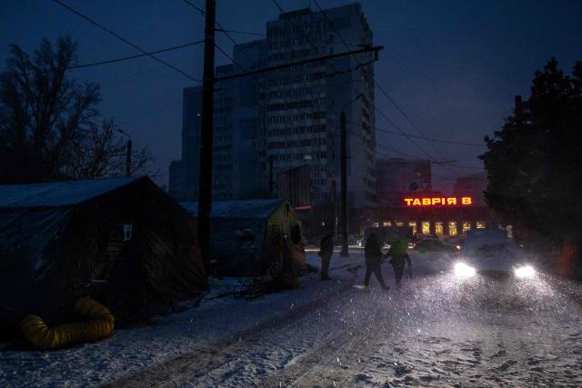 Local residents walk past heated tents during a power outage in Odesa on February 18, 2026, amid the Russian invasion of Ukraine. (Photo by Oleksandr GIMANOV / AFP)