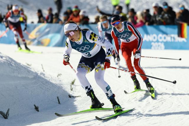 Sweden's Ebba Andersson (L) and Norway's Heidi Weng compete during the women's cross country 50km mass start final event of the Milano Cortina 2026 Winter Olympic Games at Tesero Cross-Country Skiing Stadium in Lago di Tesero (Val di Fiemme), on February 22, 2026. (Photo by Anne-Christine POUJOULAT / AFP)