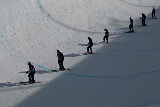 Slippers smooth out the halfpipe before the freestyle skiing women's freeski halfpipe final run 1 during the Milano Cortina 2026 Winter Olympic Games at Livigno Snow Park, in Livigno (Valtellina), on February 22, 2026. (Photo by Kirill KUDRYAVTSEV / AFP)