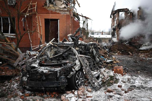 This photograph shows a destroyed car at the site of an air attack in Sofiivska Borshchagivka, Kyiv region on February 22, 2026, amid the Russian invasion of Ukraine. Explosions rocked Ukraine's capital Kyiv with officials warning of a ballistic missile attack, just two days before the fourth anniversary of Russia's invasion. (Photo by Henry Nicholls / AFP)