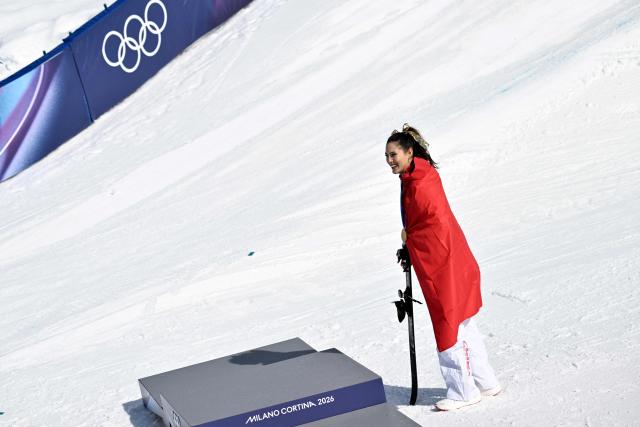 Gold medallist China's Gu Ailing Eileen celebrates on the podium after winning the freestyle skiing women's freeski halfpipe final during the Milano Cortina 2026 Winter Olympic Games at Livigno Snow Park, in Livigno (Valtellina), on February 22, 2026. (Photo by Jeff PACHOUD / AFP)