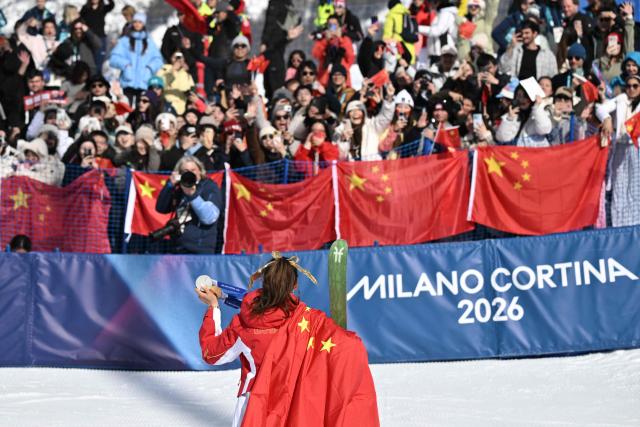 Gold medallist China's Gu Ailing Eileen celebrates with her three olympic medals (two silver and one gold medal) in front of fans after winning the freestyle skiing women's freeski halfpipe final during the Milano Cortina 2026 Winter Olympic Games at Livigno Snow Park, in Livigno (Valtellina), on February 22, 2026. (Photo by Jeff PACHOUD / AFP)