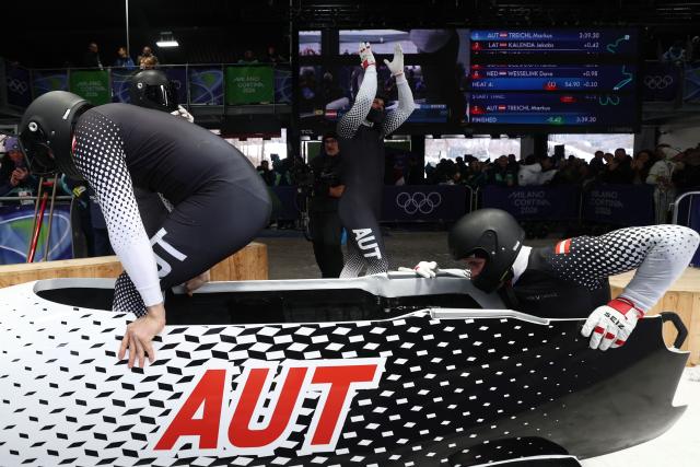 Austria's Markus Treichl, Austria's Markus Sammer, Austria's Sascha Stepan and Austria's Kristian Huber react after crossing the finish line in the bobsleigh men's 4-man heat 4 at Cortina Sliding Centre during the Milano Cortina 2026 Winter Olympic Games in Cortina d'Ampezzo on February 22, 2026. (Photo by FRANCK FIFE / AFP)