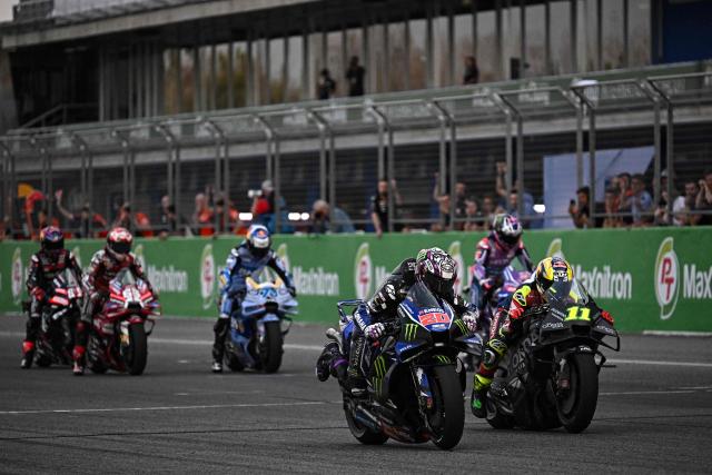 Monster Energy Yamaha's French rider Fabio Quatararo (#20, front L) and Honda LCR's Brazilian rider Diogo Moreira (#11, front R) practice their starts on the track during the second day of the 2026 MotoGP pre-season test at the Buriram International Circuit in Buriram on February 22, 2026. (Photo by Lillian SUWANRUMPHA / AFP)