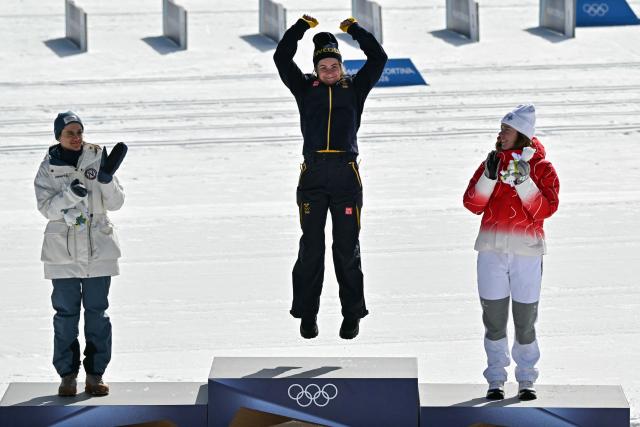 (From L) Silver medallist Norway's Heidi Weng, gold medallist Sweden's Ebba Andersson and bronze medallist Switzerland's Nadja Kaelin celebrate on the podium the women's cross country 50km mass start final event of the Milano Cortina 2026 Winter Olympic Games at Tesero Cross-Country Skiing Stadium in Lago di Tesero (Val di Fiemme), on February 22, 2026. (Photo by Javier SORIANO / AFP)
