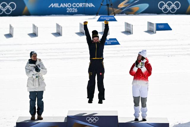 (From L) Silver medallist Norway's Heidi Weng, gold medallist Sweden's Ebba Andersson and bronze medallist Switzerland's Nadja Kaelin celebrate on the podium the women's cross country 50km mass start final event of the Milano Cortina 2026 Winter Olympic Games at Tesero Cross-Country Skiing Stadium in Lago di Tesero (Val di Fiemme), on February 22, 2026. (Photo by Javier SORIANO / AFP)