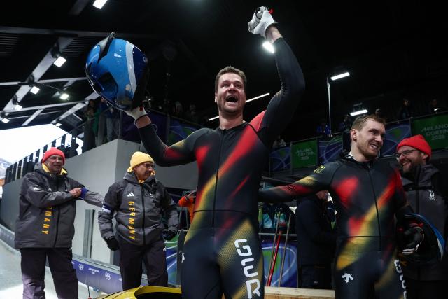 Germany's Johannes Lochner (C) celebrates with teammates Germany's Thorsten Margis, Germany's Jorn Wenzel and Germany's Georg Fleischhauer after winning the bobsleigh men's 4-man heat 4 at Cortina Sliding Centre during the Milano Cortina 2026 Winter Olympic Games in Cortina d'Ampezzo on February 22, 2026. (Photo by FRANCK FIFE / AFP)