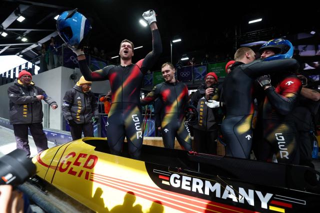 Germany's Johannes Lochner (L) celebrates with teammates Germany's Thorsten Margis, Germany's Jorn Wenzel and Germany's Georg Fleischhauer after winning the bobsleigh men's 4-man heat 4 at Cortina Sliding Centre during the Milano Cortina 2026 Winter Olympic Games in Cortina d'Ampezzo on February 22, 2026. (Photo by FRANCK FIFE / AFP)