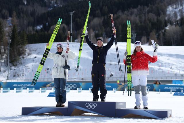 (From L) Silver medallist Norway's Heidi Weng, gold medallist Sweden's Ebba Andersson and bronze medallist Switzerland's Nadja Kaelin celebrate on the podium of the women's cross country 50km mass start final event of the Milano Cortina 2026 Winter Olympic Games at Tesero Cross-Country Skiing Stadium in Lago di Tesero (Val di Fiemme), on February 22, 2026. (Photo by Anne-Christine POUJOULAT / AFP)