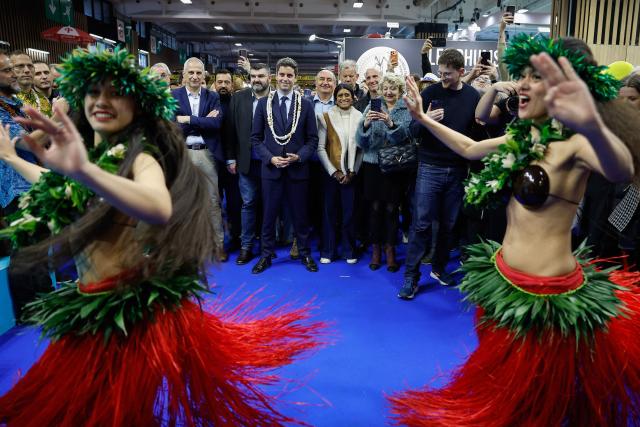 President of Ensemble Pour la Republique parliamentary group Gabriel Attal (C) accompanied by Ensemble Pour la Republique's MP Jean-Luc Fugit (C-L) looks at dancers performing at the Tahiti stall as he visits the International Agricultural Show (Salon de l'Agriculture) at Paris Expo Porte de Versailles in Paris on February 22, 2026. (Photo by Charlotte SIEMON / AFP)