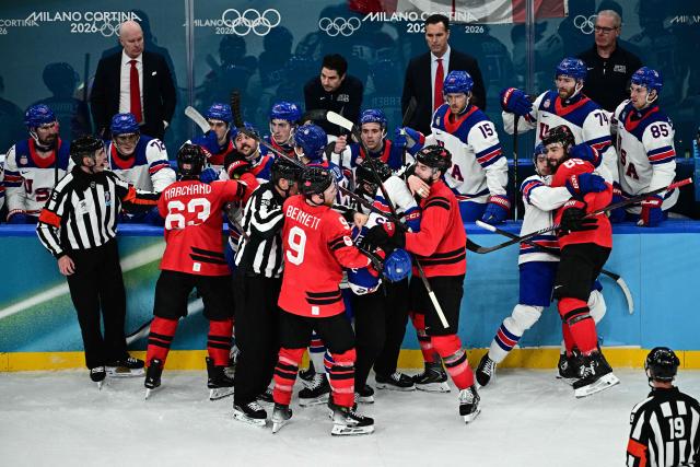 Canada's players and USA's players fight during the men's gold medal ice hockey match between Canada and USA at the Milano Santagiulia Ice Hockey Arena during the Milano Cortina 2026 Winter Olympic Games in Milan, on February 22, 2026. (Photo by JULIEN DE ROSA / AFP)