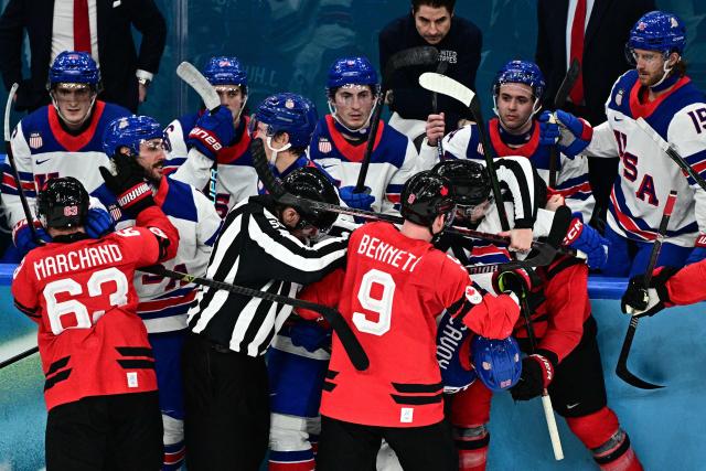 Canada's players and USA's players fight during the men's gold medal ice hockey match between Canada and USA at the Milano Santagiulia Ice Hockey Arena during the Milano Cortina 2026 Winter Olympic Games in Milan, on February 22, 2026. (Photo by JULIEN DE ROSA / AFP)