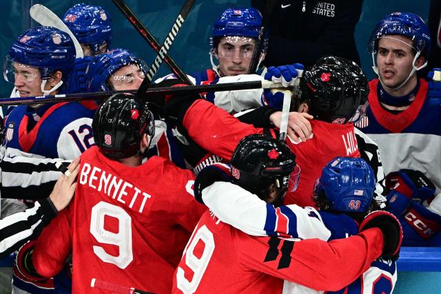 Canada's players and USA's players fight during the men's gold medal ice hockey match between Canada and USA at the Milano Santagiulia Ice Hockey Arena during the Milano Cortina 2026 Winter Olympic Games in Milan, on February 22, 2026. (Photo by JULIEN DE ROSA / AFP)