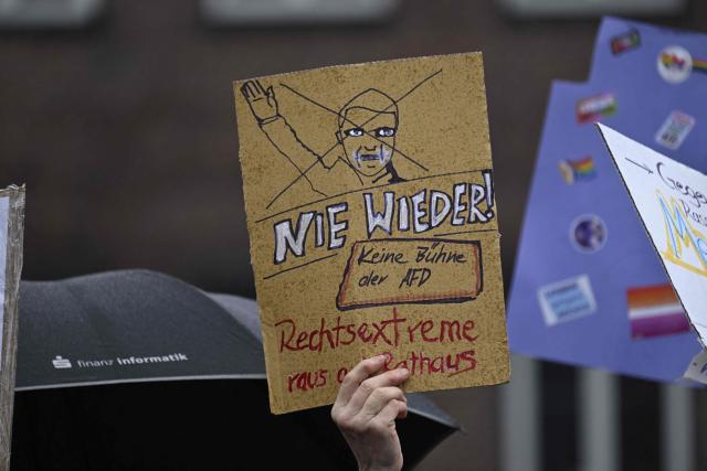 Demonstrators hold placards reading 'never again' (Nie wieder) as they protest on February 22, 2026 in Dortmund, western Germany, against the appearance of a controversial far-right politician at the new year's reception of the far-right Alternative for Germany (AfD) party's faction in the Dortmund city council. After a legal tug-of-war, Bjoern Hoecke, regional chairman of the far-right Alternative for Germany (AfD) party in Thuringia, was granted permission by a court to give a speech at the event, although the city's mayor had tried to prevent this. (Photo by INA FASSBENDER / AFP)