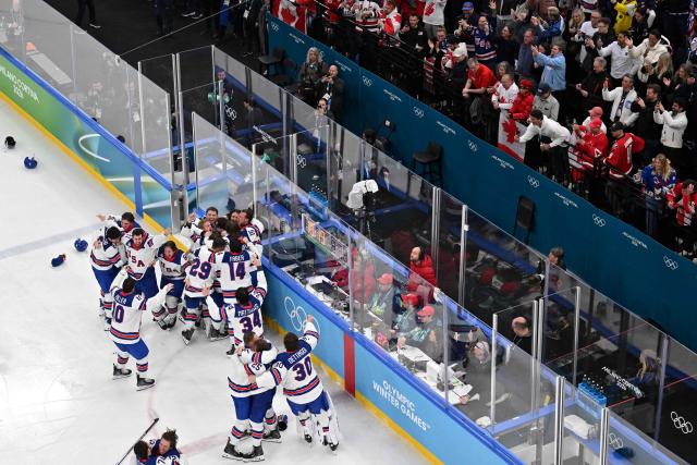 Members of the audience applaud as USA's players celebrates after winning the men's gold medal ice hockey match between Canada and USA at the Milano Santagiulia Ice Hockey Arena during the Milano Cortina 2026 Winter Olympic Games in Milan, on February 22, 2026. (Photo by Antonin THUILLIER / AFP)