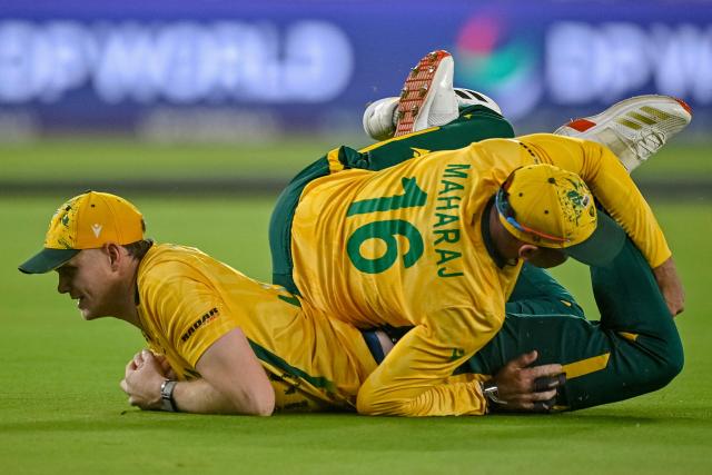 South Africa's Corbin Bosch (L) collides with teammate Keshav Maharaj after taking a catch to dismiss India's Abhishek Sharma during the 2026 ICC Men's T20 Cricket World Cup Super Eights match between India and South Africa at the Narendra Modi Stadium in Ahmedabad on February 22, 2026. (Photo by Shammi MEHRA / AFP)