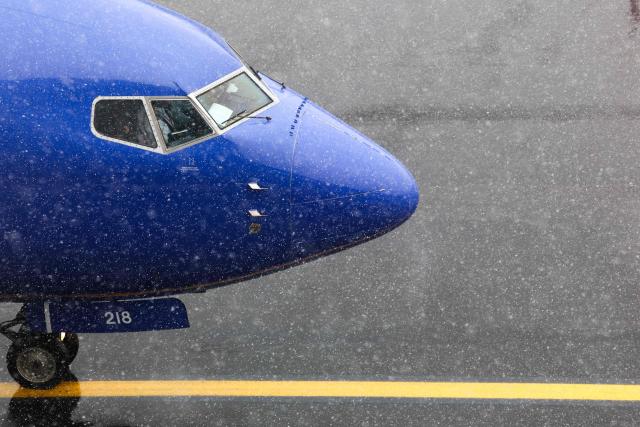 Snow falls as a Boeing 737 Southwest Airlines passenger aircraft prepares to take off from  LaGuardia Airport in New York on February 22, 2026. A fast-developing storm is threatening to pummel the US East Coast with a foot or more of snow beginning Sunday, bringing Mother Nature's wrath to a region that only just dug out from a previous winter wallop. Meteorologists issued blizzard warnings for New York and parts of at least six states, warning Saturday that heavy snow and gale-force winds are forecast to slam all major cities along the densely populated Interstate 95 northeast corridor, including Philadelphia, Boston and even Washington further south. (Photo by CHARLY TRIBALLEAU / AFP)