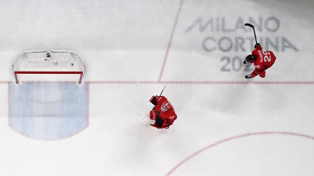 Canada's #50 Jordan Binnington (L) and Canada's #29 Nathan MacKinnon react after their 1-2 defeat in overtime in the men's gold medal ice hockey match between Canada and USA at the Milano Santagiulia Ice Hockey Arena during the Milano Cortina 2026 Winter Olympic Games in Milan, on February 22, 2026. (Photo by JULIEN DE ROSA / AFP)