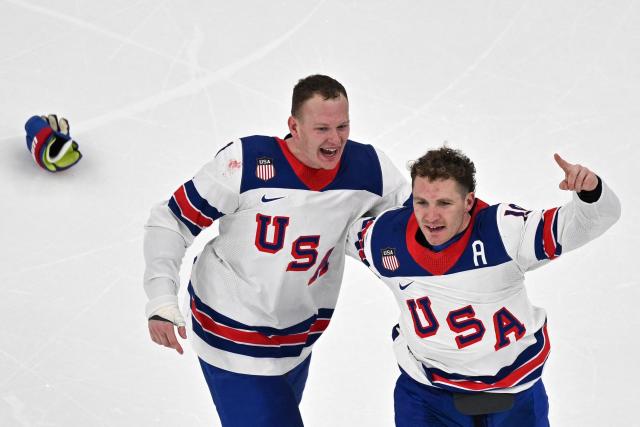 USA's #07 Brady Tkachuk (L) and team mate celebrate after winning the men's gold medal ice hockey match between Canada and USA at the Milano Santagiulia Ice Hockey Arena during the Milano Cortina 2026 Winter Olympic Games in Milan, on February 22, 2026. (Photo by Antonin THUILLIER / AFP)