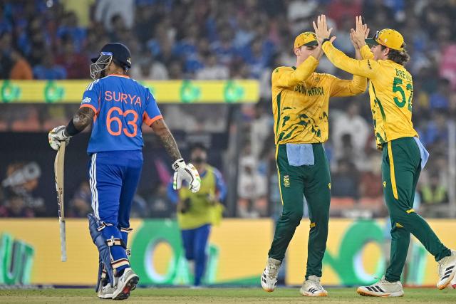 South Africa's Dewald Brevis (R) celebrates with teammate Tristan Stubbs (C) after taking a catch to dismiss India's captain Suryakumar Yadav (L) during the 2026 ICC Men's T20 Cricket World Cup Super Eights match between India and South Africa at the Narendra Modi Stadium in Ahmedabad on February 22, 2026. (Photo by Shammi MEHRA / AFP)