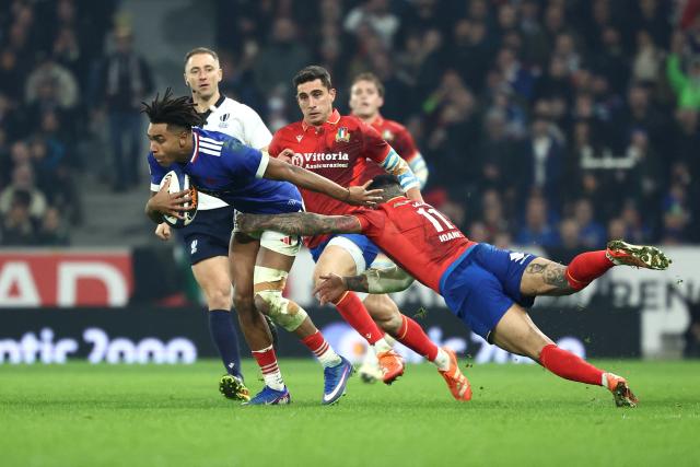 France's wing Théo Attissogbe escapes from Italy's wing Monty Loane's tackle (R) during the Six Nations international rugby union match between France and Italy at the Stade Pierre-Mauroy in Villeneuve-d'Ascq, northern France, on February 22, 2026. (Photo by Sameer AL-DOUMY / AFP)