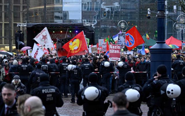 Demonstrators protest on February 22, 2026 in front of the city hall in Dortmund, western Germany, against the appearance of a controversial far-right politician at the new year's reception of the far-right Alternative for Germany (AfD) party's faction in the Dortmund city council. After a legal tug-of-war, Bjoern Hoecke, regional chairman of the far-right Alternative for Germany (AfD) party in Thuringia, was granted permission by a court to give a speech at the event, although the city's mayor had tried to prevent this. (Photo by INA FASSBENDER / AFP)