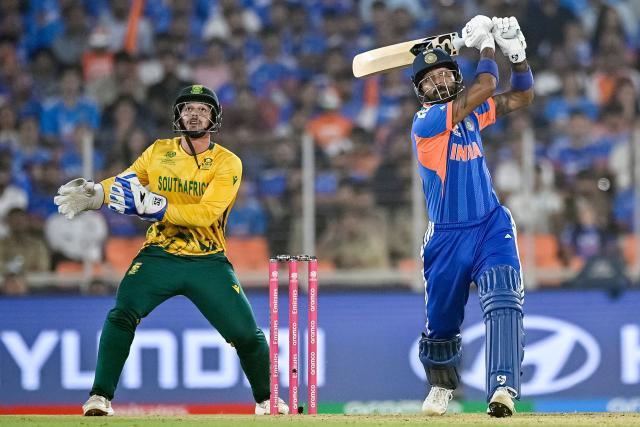 India's Hardik Pandya (R) plays a shot as South Africa's wicketkeeper Quinton de Kock reacts during the 2026 ICC Men's T20 Cricket World Cup Super Eights match between India and South Africa at the Narendra Modi Stadium in Ahmedabad on February 22, 2026. (Photo by Shammi MEHRA / AFP)