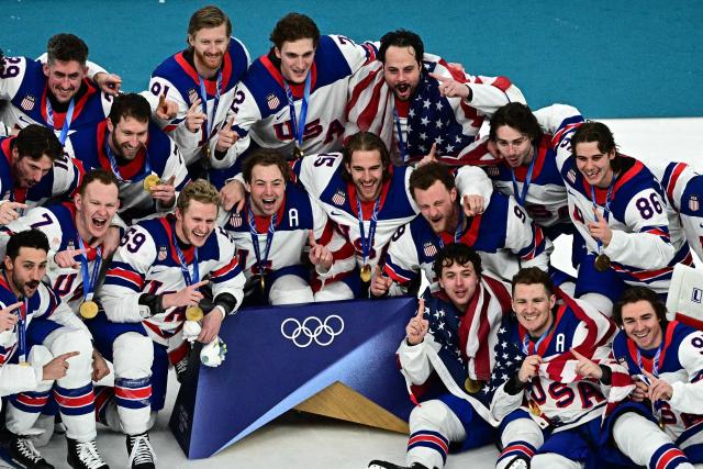 Gold medallists USA's players celebrate  during the medals ceremony of the men's ice hockey event at the Milano Santagiulia Ice Hockey Arena during the Milano Cortina 2026 Winter Olympic Games in Milan, on February 22, 2026. (Photo by JULIEN DE ROSA / AFP)
