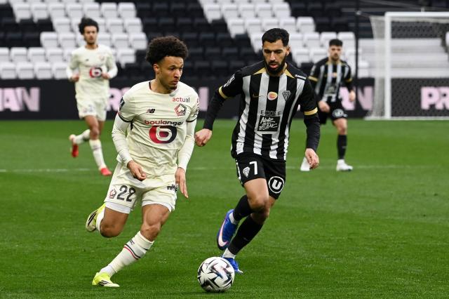 Lille's Portuguese defender #22 Tiago Santos (L) fight for the ball with Angers' French-Moroccan midfielder #07 Amine Sbai during the French L1 football match between SCO Angers and Lille LOSC at the Raymond-Kopa Stadium in Angers, western France, on February 22, 2026. (Photo by JEAN-FRANCOIS MONIER / AFP)