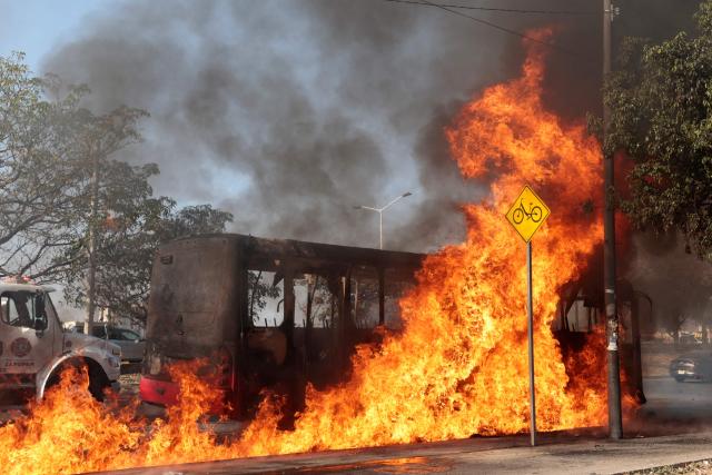 A bus burns at one of the main avenues after it was set on fire by organised crime groups in response to an operation in Jalisco to arrest a high-priority security target in Zapopan, state of Jalisco, Mexico, on February 22, 2026. Armed civilians blocked several roads in the state of Jalisco, in western Mexico, following an operation by federal forces in the town of Tapalpa, local authorities reported. Jalisco, which will host four matches of the upcoming 2026 World Cup, is home to the powerful Jalisco New Generation Cartel (CJNG), and has been rocked by several episodes of violence in recent years. (Photo by Ulises RUIZ / AFP)