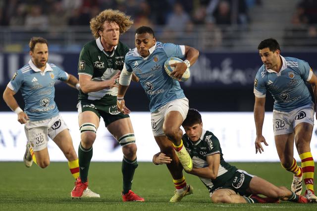Perpignan's Fijian centre Alivereti Duguivalu (C) runs with the ball to score his team first try during the French Top 14 rugby union match between USA Perpignan and Section Paloise Bearn Pyrenees (Pau) at the Aime-Giral stadium in Perpignan, south-western France on February 22, 2026. (Photo by Valentine CHAPUIS / AFP)