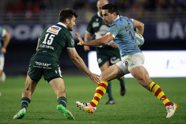 Perpignan's Argentine centre Jeronimo De La Fuente (R) is tackled by Pau's French full-back Aymeric Luc (L) during the French Top 14 rugby union match between USA Perpignan and Section Paloise Bearn Pyrenees (Pau) at the Aime-Giral stadium in Perpignan, south-western France on February 22, 2026. (Photo by Valentine CHAPUIS / AFP)