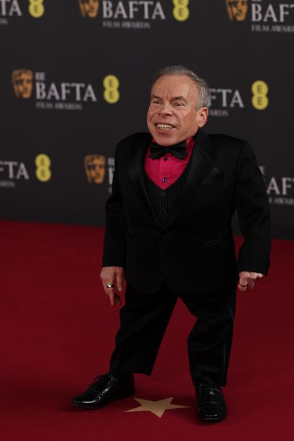 British actor Warwick Davis poses on the red carpet upon arrival at the BAFTA British Academy Film Awards at the Royal Festival Hall, Southbank Centre, in London, on February 22, 2026. (Photo by Adrian Dennis / AFP)