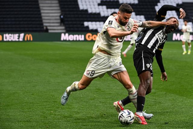 Lille's French forward #09 Olivier Giroud (L) fights for the ball with Angers' Gabonese defender #03 Jacques Ekomie during the French L1 football match between SCO Angers and Lille LOSC at the Raymond-Kopa Stadium in Angers, western France, on February 22, 2026. (Photo by JEAN-FRANCOIS MONIER / AFP)