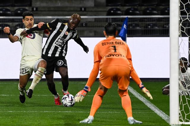 Lille's French midfielder #21 Benjamin Andre (L) fights for the ball with Angers' Gabonese defender #03 Jacques Ekomie (C) in front of Lille's Turkish goalkeeper #01 Berke Ozer during the French L1 football match between SCO Angers and Lille LOSC at the Raymond-Kopa Stadium in Angers, western France, on February 22, 2026. (Photo by JEAN-FRANCOIS MONIER / AFP)
