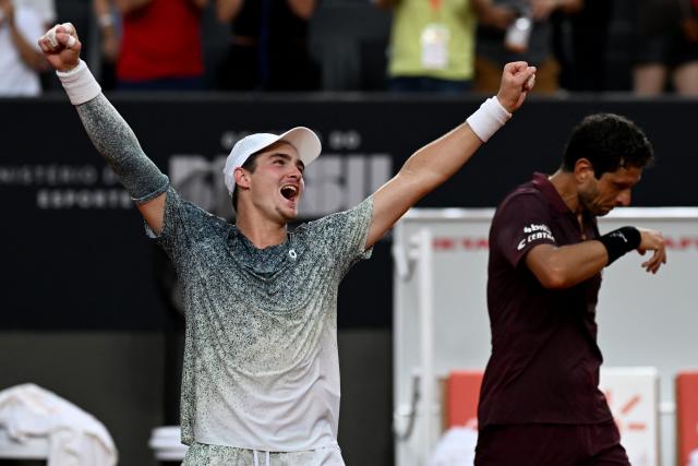 Brazil's Joao Fonseca (L) celebrates beside his partner Brazil's Marcelo Melo after winning their men's doubles final match against Netherlands's Robin Haase and Germany's Constantin Frantzen at the Rio Open tennis tournament in Rio de Janeiro, Brazil, on February 22, 2026. (Photo by MAURO PIMENTEL / AFP)