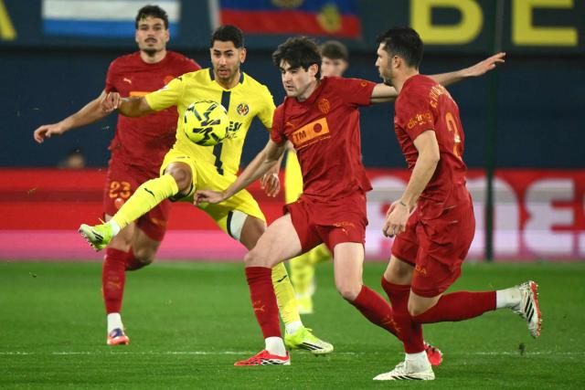 Villarreal's Spanish forward #22 Ayoze Perez Gutierrez (2L) and Valencia's Spanish midfielder # 08 Javi Guerra (2R) fight for the ball during the Spanish league football match between Villarreal CF and Valencia CF at La Ceramica Stadium in Vila-real on February 22, 2026. (Photo by JOSE JORDAN / AFP)