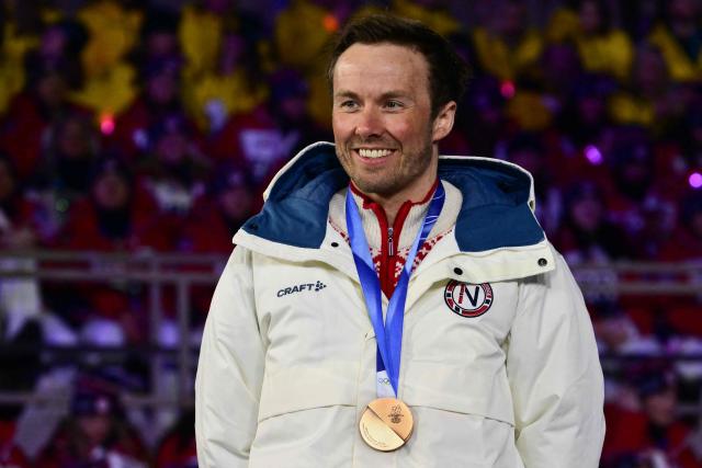 Bronze medallist Norway's Emil Iversen celebrates on the podium for the men's cross country 50km mass start final event of the Milano Cortina 2026 Winter Olympic Games, within the games' closing ceremony at the Verona Arena in Verona on February 22, 2026. (Photo by Stefano RELLANDINI / AFP)