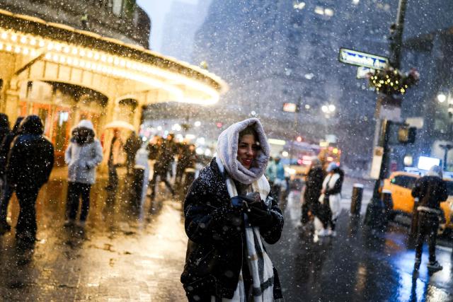 A woman walks in a street in the Manhattan borough of New York City on February 22, 2026. A fast-developing storm is threatening to pummel the US East Coast with a foot (30cm) or more of snow beginning Sunday, bringing Mother Nature's wrath to a region that only just dug out from a previous winter wallop. Meteorologists issued blizzard warnings for New York and parts of at least six states, warning Saturday that heavy snow and gale-force winds are forecast to slam all major cities along the densely populated Interstate 95 northeast corridor, including Philadelphia, Boston and even Washington further south. (Photo by CHARLY TRIBALLEAU / AFP)