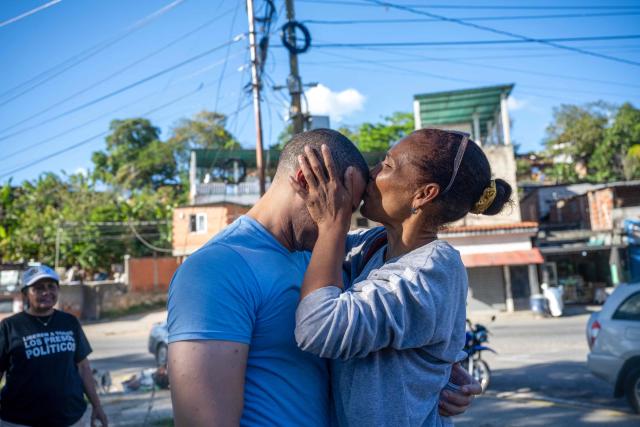 Venezuelan prisoner Jose Damasco (L) greets his relatives after being released from El Rodeo I prison in Guatire, Miranda state, Venezuela on February 22, 2026. More than 200 Venezuelan political prisoners were on hunger strike Sunday to demand their release under a new amnesty law that excludes many of them. The amnesty was approved by Venezuela's congress on February 19, 2026, as part of a wave of reforms encouraged by the United States after it ousted and captured former president Nicolas Maduro on January 3. (Photo by Maryorin Mendez / AFP)