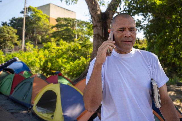 Richard Corona speaks on a mobile phone after being released from El Rodeo I prison in Guatire, Miranda State, Venezuela, on February 22, 2026. More than 200 Venezuelan political prisoners were on hunger strike Sunday to demand their release under a new amnesty law that excludes many of them. The amnesty was approved by Venezuela's congress on February 19, 2026, as part of a wave of reforms encouraged by the United States after it ousted and captured former president Nicolas Maduro on January 3. (Photo by Maryorin Mendez / AFP)