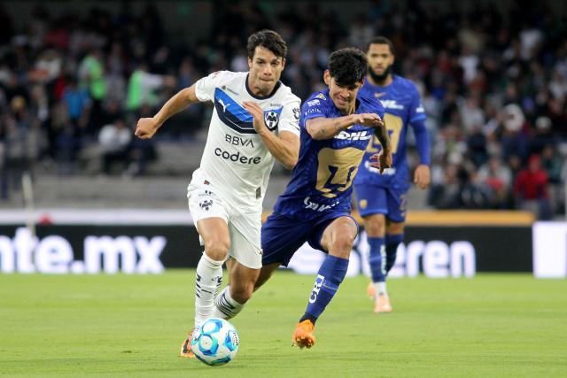 Monterrey's Spanish midfielder #08 Oliver Torres (L) runs with the ball past Pumas' Paraguayan forward #31 Robert Morales (R) during the Liga MX Clausura match between Pumas and Monterrey at Olimpico Universitario Stadium in Mexico City on February 22, 2026. (Photo by Victor Cruz / AFP)