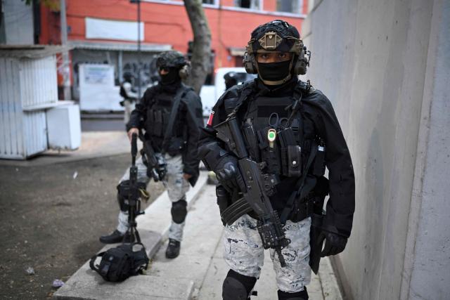 Mexican National Guard special forces stand guard around the Specialized Prosecutor's Office for Organized Crime (FEMDO) headquarters in Mexico City, Mexico, February 22, 2026. Mexico confirmed on February 22, 2026, that soldiers killed a powerful drug cartel leader who was one of the most wanted men here and in the United States. Nemesio Oseguera, the 59-year-old leader of the violent Jalisco New Generation Cartel, was wounded in a clash with soldiers in the town of Tapalpa and died while being flown to Mexico City, the army said in a statement. (Photo by Alfredo ESTRELLA / AFP)