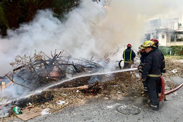 Firefighters try to extinguish a fire at an open-air garbage dumping site in a neighborhood of Havana, on February 22, 2026.  (Photo by Yamil LAGE / AFP)
