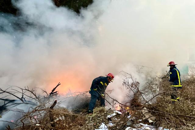Firefighters work to put out a fire at an open-air garbage dumping site in a neighborhood of Havana, on February 22, 2026.  (Photo by Yamil LAGE / AFP)