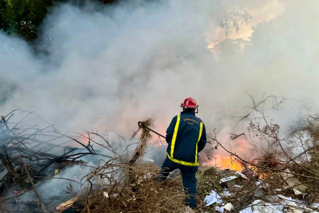 A firefighter works to put out a fire at an open-air garbage dumping site in a neighborhood of Havana, on February 22, 2026.  (Photo by Yamil LAGE / AFP)