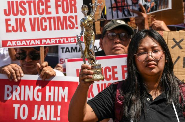 TOPSHOT - Activists and supporters of families of the victims of extrajudicial killings of former Philippine president Rodrigo Duterte's drug war take part in a protest in Manila on February 23, 2026. A hearing begins at the International Criminal Court (ICC) on February 23 that will determine whether Duterte will stand trial over at least 76 of those deaths. (Photo by Ted ALJIBE / AFP)