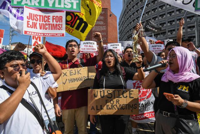 Activists and supporters of families of the victims of extrajudicial killings of former Philippine president Rodrigo Duterte's drug war take part in a protest in Manila on February 23, 2026. A hearing begins at the International Criminal Court (ICC) on February 23 that will determine whether Duterte will stand trial over at least 76 of those deaths. (Photo by Ted ALJIBE / AFP)
