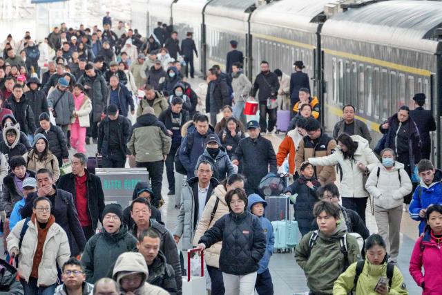 Passengers get off a train at Yantai, in China’s eastern Shandong province on February 23, 2026, the final day of the Spring Festival holiday marking the Lunar New Year of the Horse. (Photo by CN-STR / AFP) / China OUT