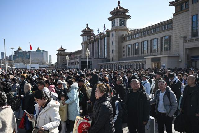 People arrive at Beijing Railway Station on February 23, 2026, the final day of the Spring Festival holiday marking the Lunar New Year of the Horse. (Photo by Pedro PARDO / AFP)